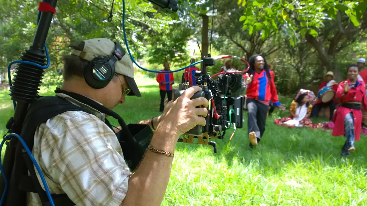 Camera operator filming traditional Malagasy dancers and musicians
